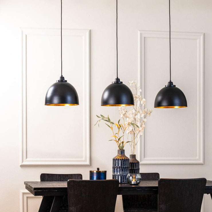 3 light black domed pendant lights with a gold interior