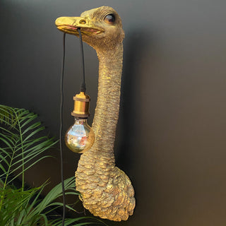 Gold ostrich bird wall lamp with a bulb hanging out of its mouth