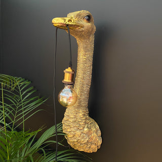 Gold ostrich bird wall lamp with a bulb hanging out of its mouth