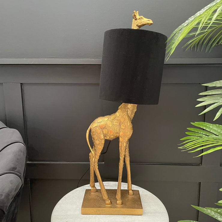 Gold giraffe table lamp with a black velvet lampshade