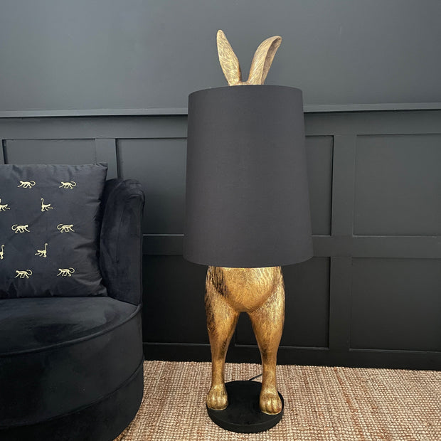 Gold bunny rabbit table and floor lamp which is hiding behind a black lampshade