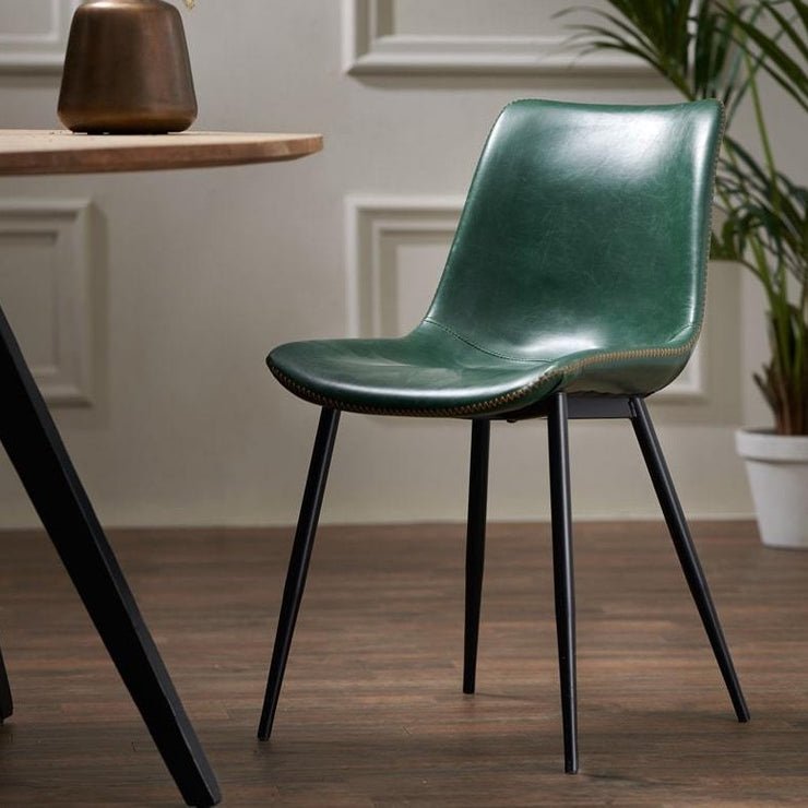 Green faux leather dining chair with four black legs