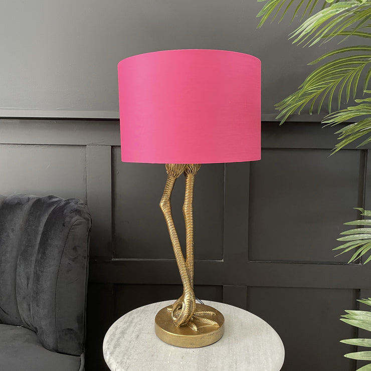 Gold flamingo leg table lamp with a bright pink round lamp shade