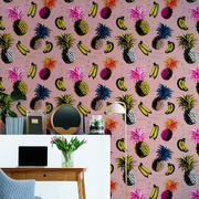 Pink wallpaper with coloured bananas and pineapple designs