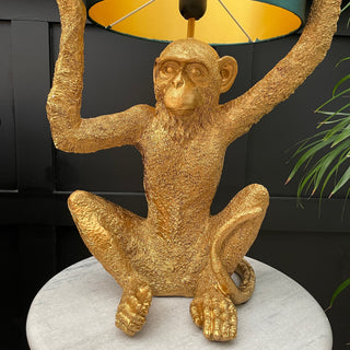 Gold sitting monkey lamp holiday a blue lampshade on it's head