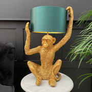 Gold sitting monkey lamp holiday a blue lampshade on it's head