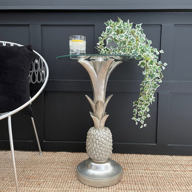 Silver pineapple side table with a circular glass top