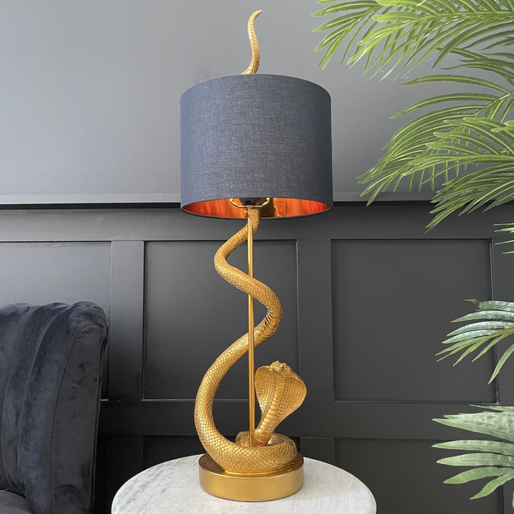 Gold snake table lamp with a black shade 