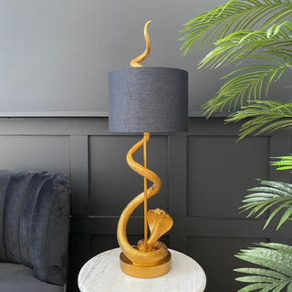 Gold snake table lamp with a black shade 