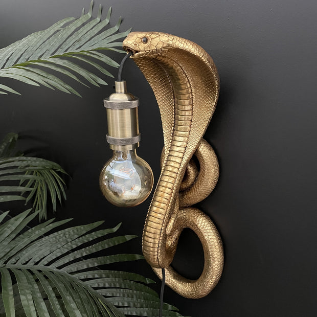 Gold snake wall light with a bulb in it's mouth